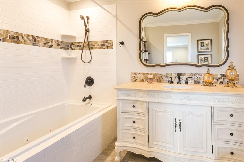 264 Welcome View Church Road Dobson, NC 27017 - Photo 17 of 30 Master bath features over size jetted tub and shower combination with decorative vanity and tile accents.