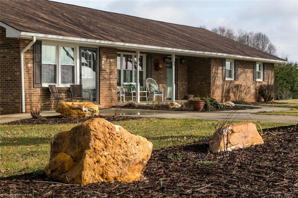 264 Welcome View Church Road Dobson, NC 27017 - Photo 26 of 30 Landscaping features rock outcroppings and several planting beds.