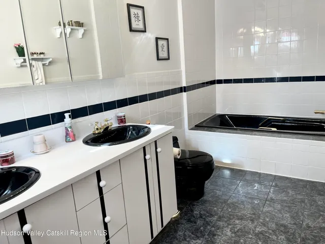 a spacious bedroom with a bed a couch and a chandelier