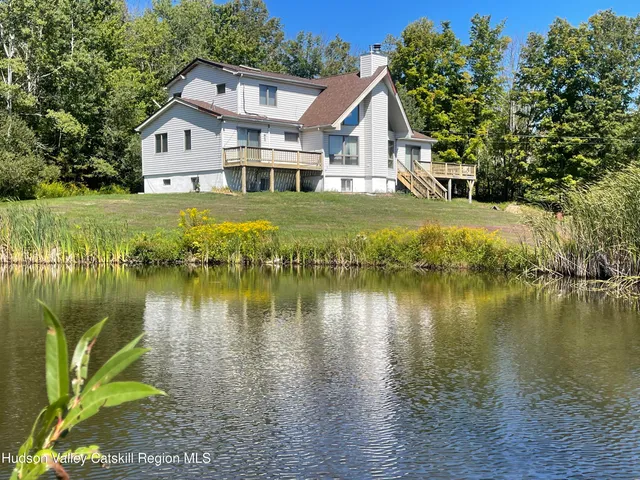 a view of a house with a yard next to a lake view