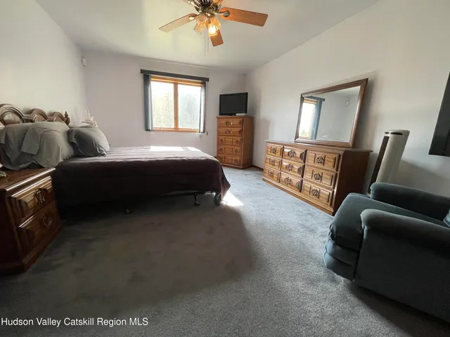 a spacious bedroom with a bed and a mirror