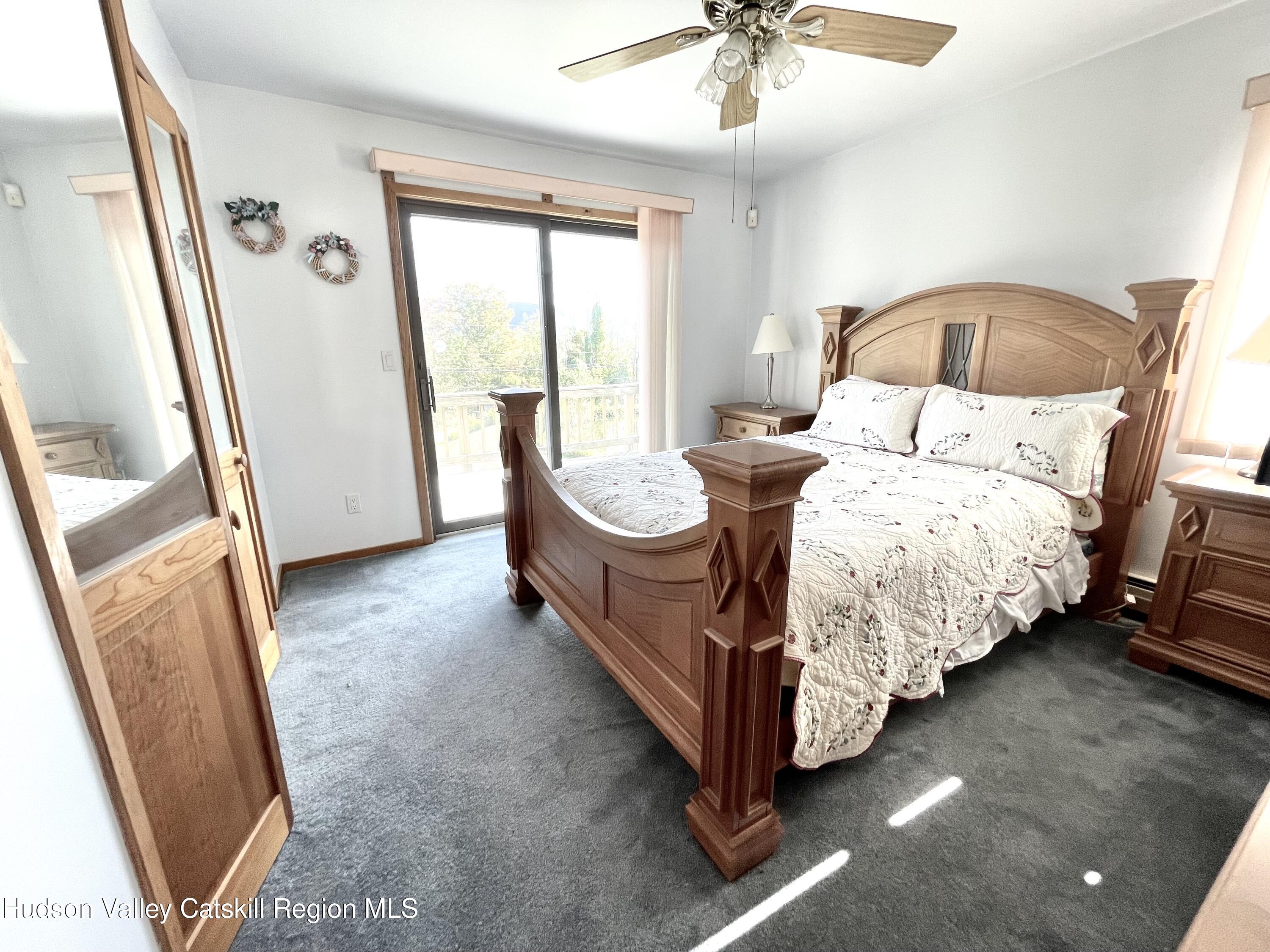 415 Old Road Windham, NY 12496 - Photo 23 of 32 a spacious bedroom with a bed and a mirror