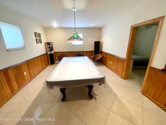a bedroom with a bed a mirror and a flat tv screen on dresser