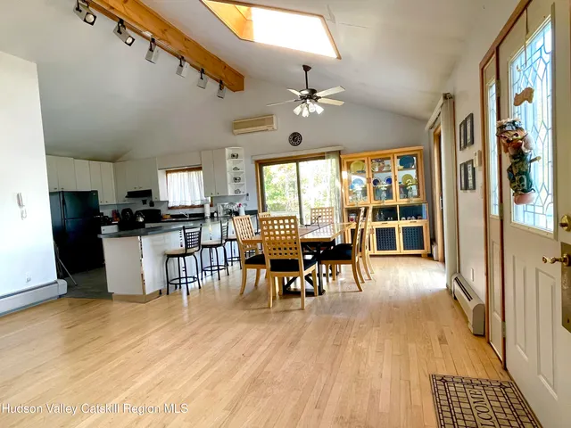 a dining room with wooden floor a glass table and chairs