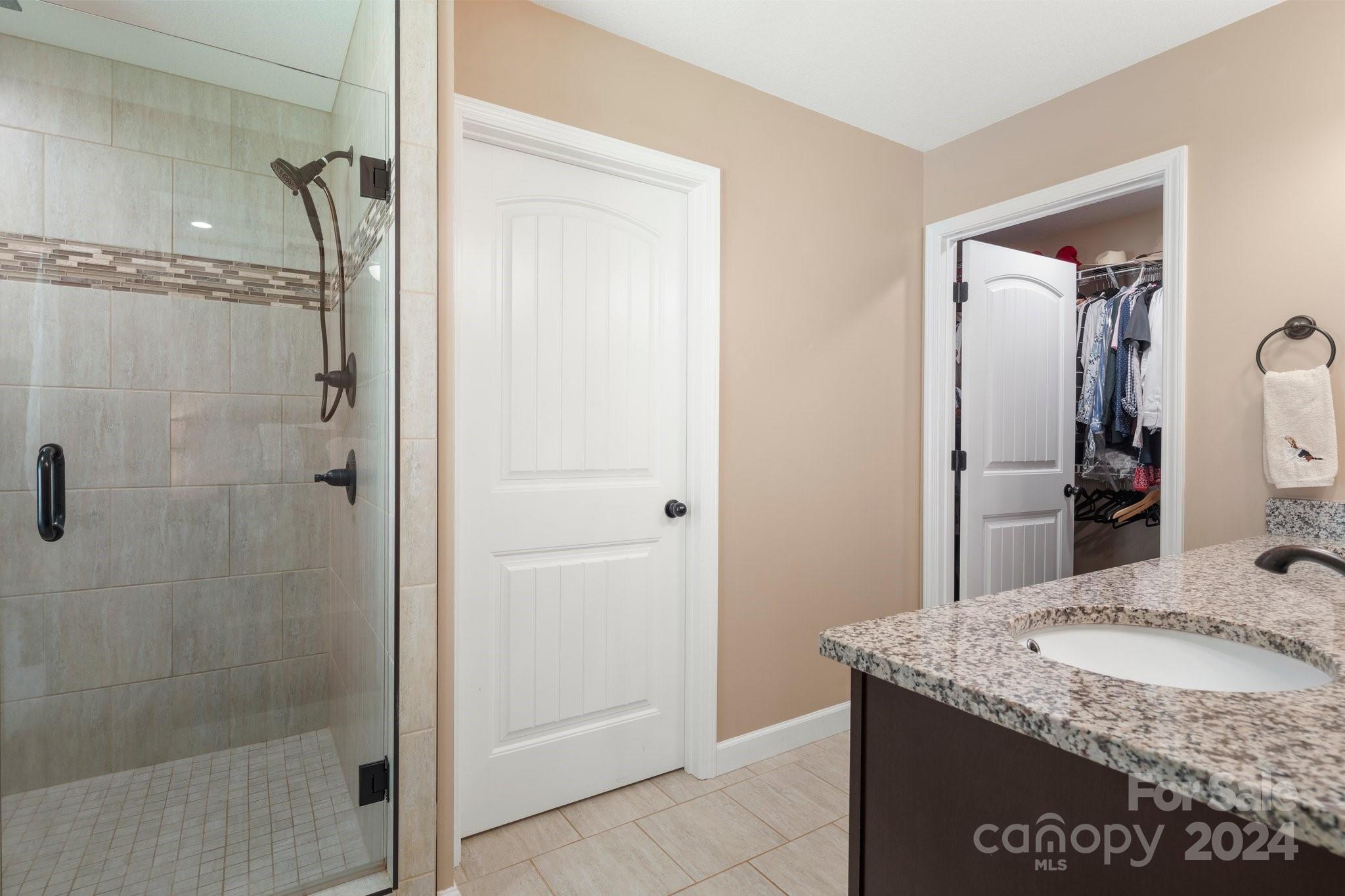 262 Renard Road Tryon, NC 28782 - Photo 20 of 31 a bathroom with a granite countertop sink a mirror and shower