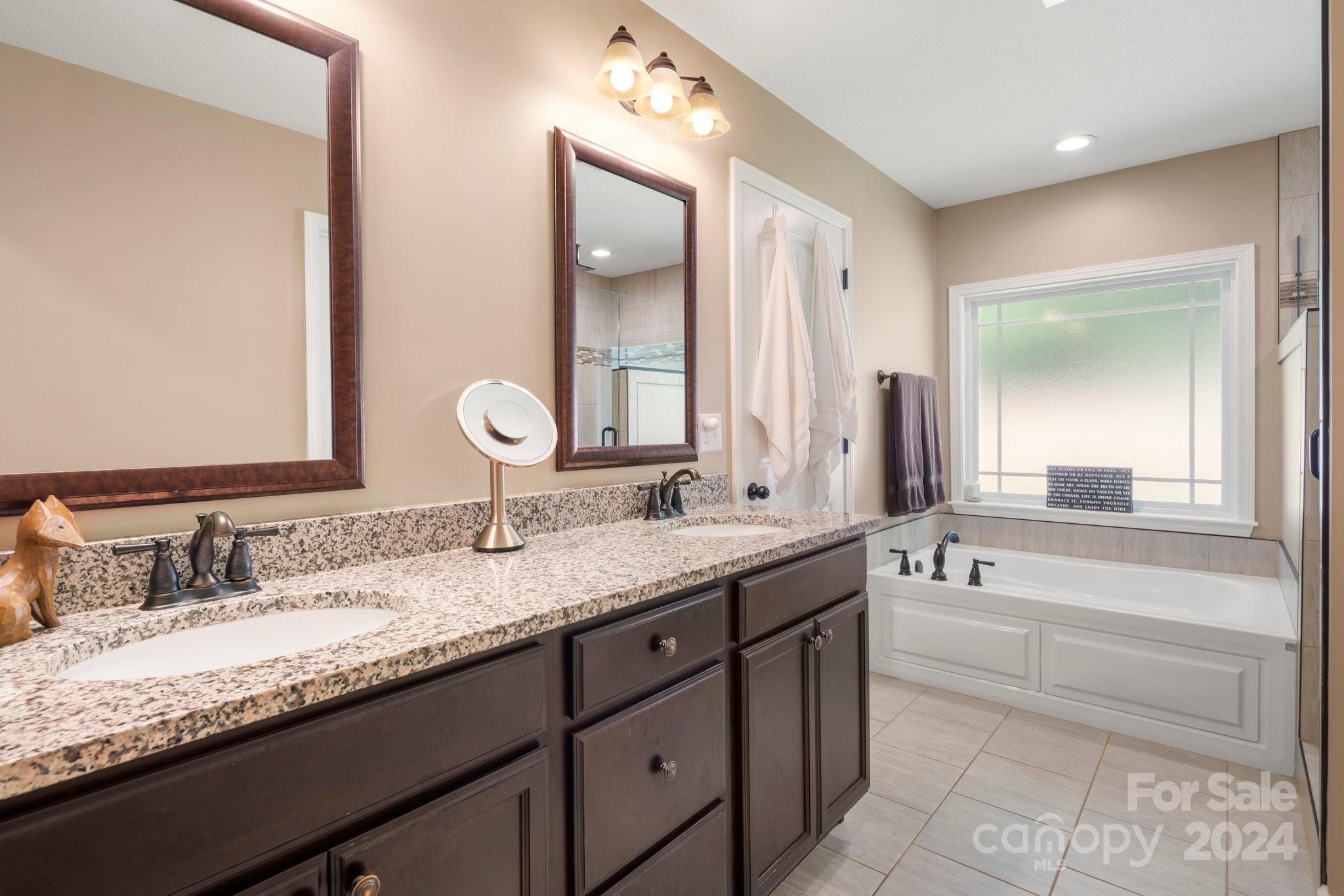 262 Renard Road Tryon, NC 28782 - Photo 21 of 31 a bathroom with a granite countertop bathtub sink double and mirror