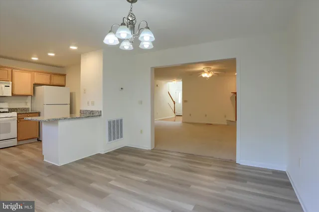 a view of a kitchen with wooden floor and a large window