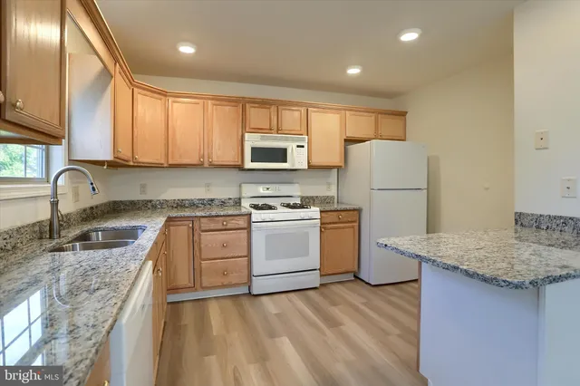a kitchen with a sink a stove a refrigerator and cabinets