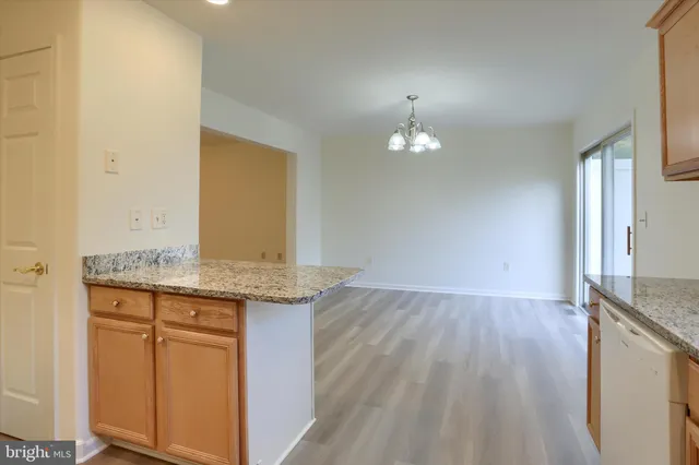 a view of a kitchen with granite countertop cabinets and wooden floor
