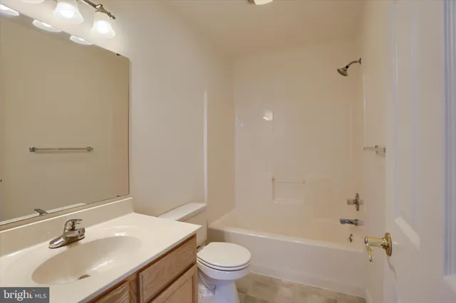 an empty room with windows and chandelier fan
