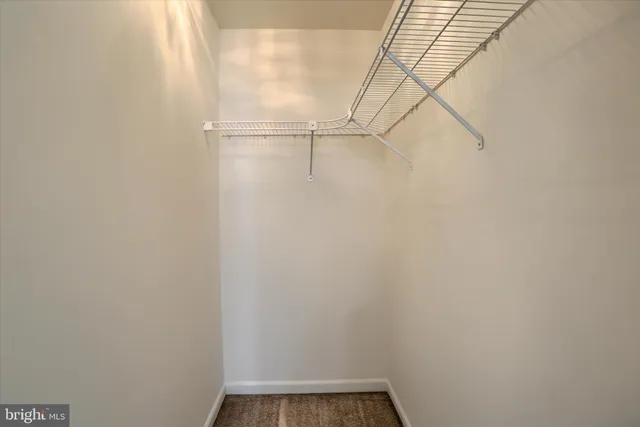 an empty room with windows and chandelier fan