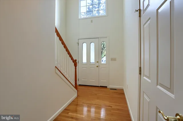 a view of a hallway with wooden floor and entryway