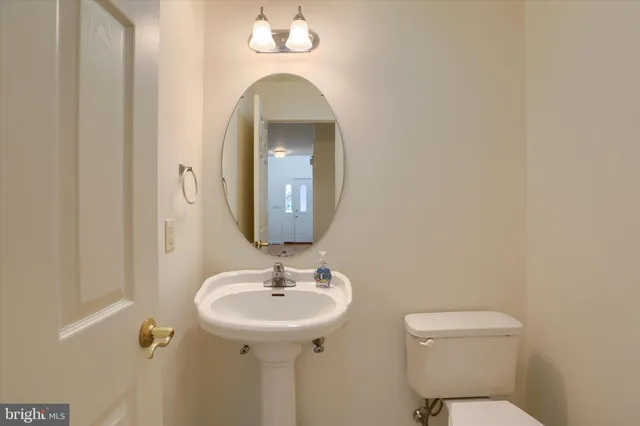 a bathroom with a toilet sink and mirror