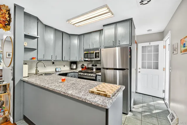 a kitchen with granite countertop stainless steel appliances a refrigerator and a sink