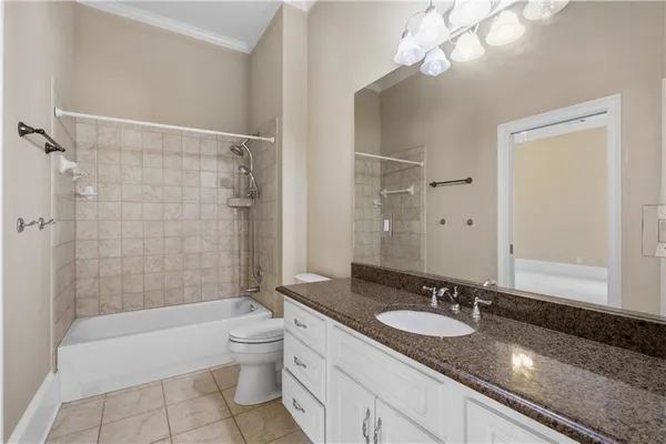 a bathroom with a granite countertop sink a toilet a mirror and shower