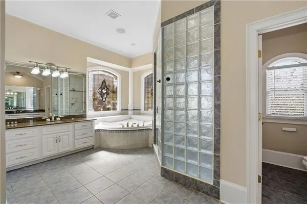 a large bathroom with a double vanity sink a large mirror and a bathtub