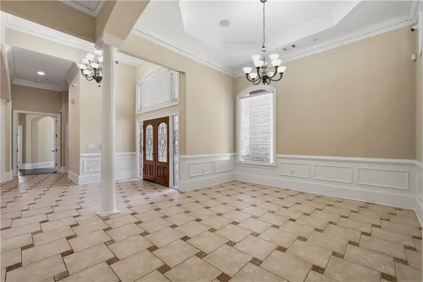 a view of a hallway with wooden floor and a chandelier