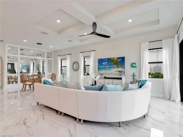 a living room with furniture kitchen view and a chandelier