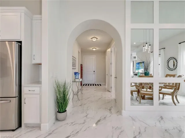 a view of a hallway with dining table and chairs