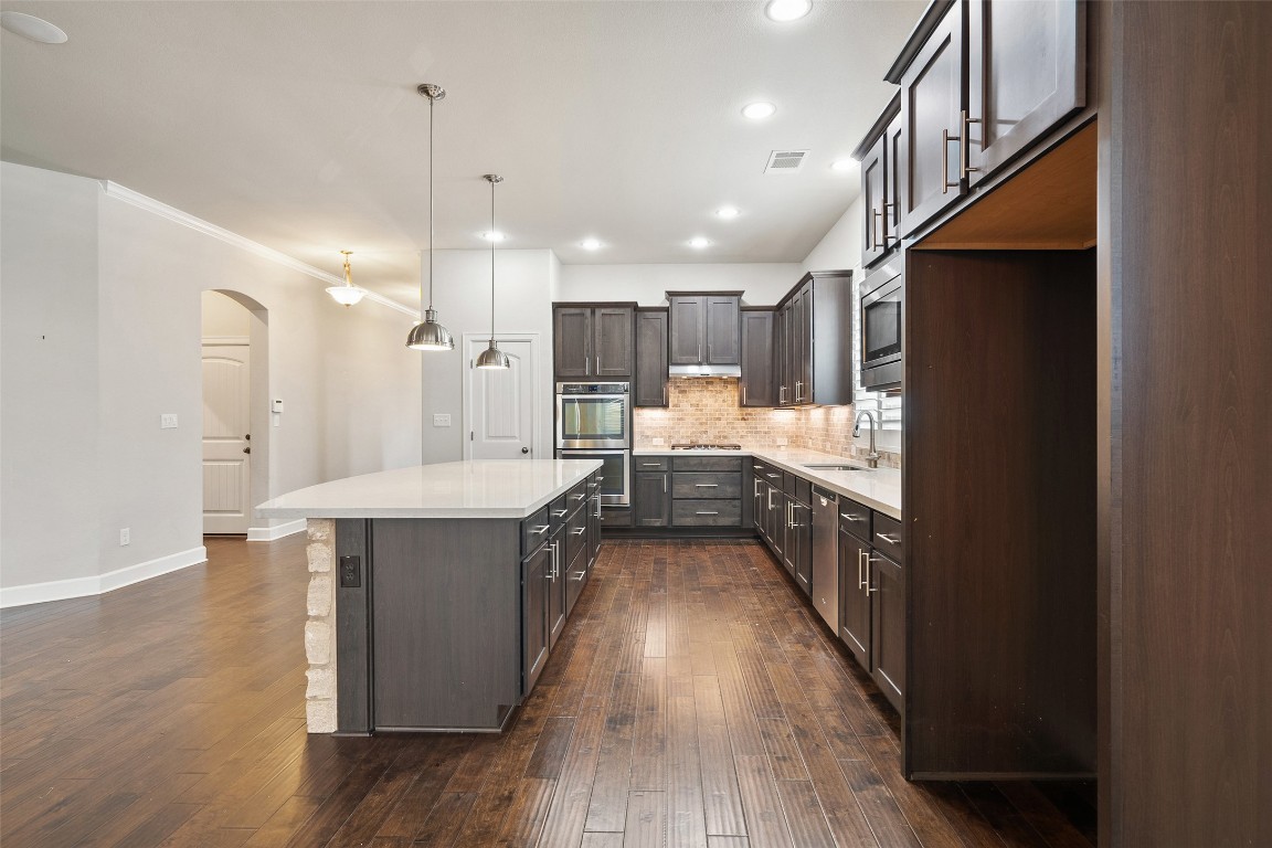 103 Lockhart Loop Georgetown, TX 78628 - Photo 13 of 40 a kitchen with kitchen island a counter top space a sink stainless steel appliances and cabinets