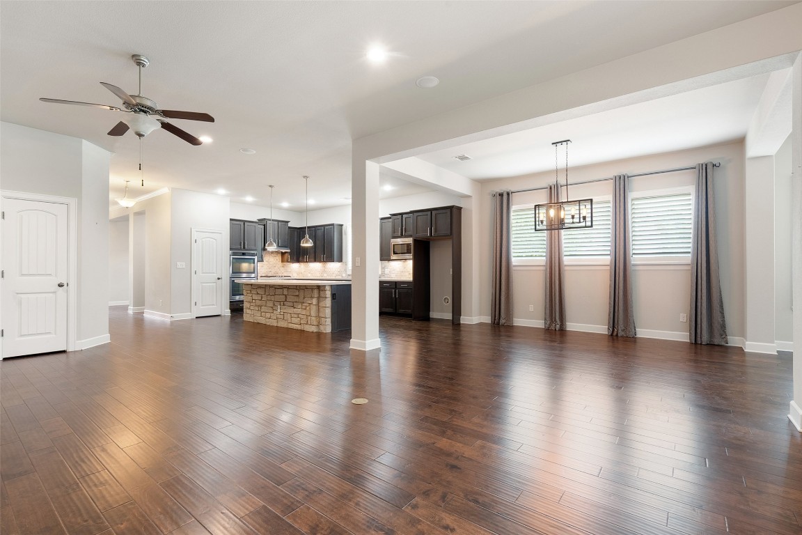 103 Lockhart Loop Georgetown, TX 78628 - Photo 20 of 40 a view of an empty room with wooden floor and a kitchen