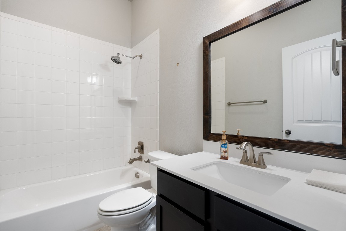 103 Lockhart Loop Georgetown, TX 78628 - Photo 24 of 40 a bathroom with a bathtub shower sink vanity mirror and toilet