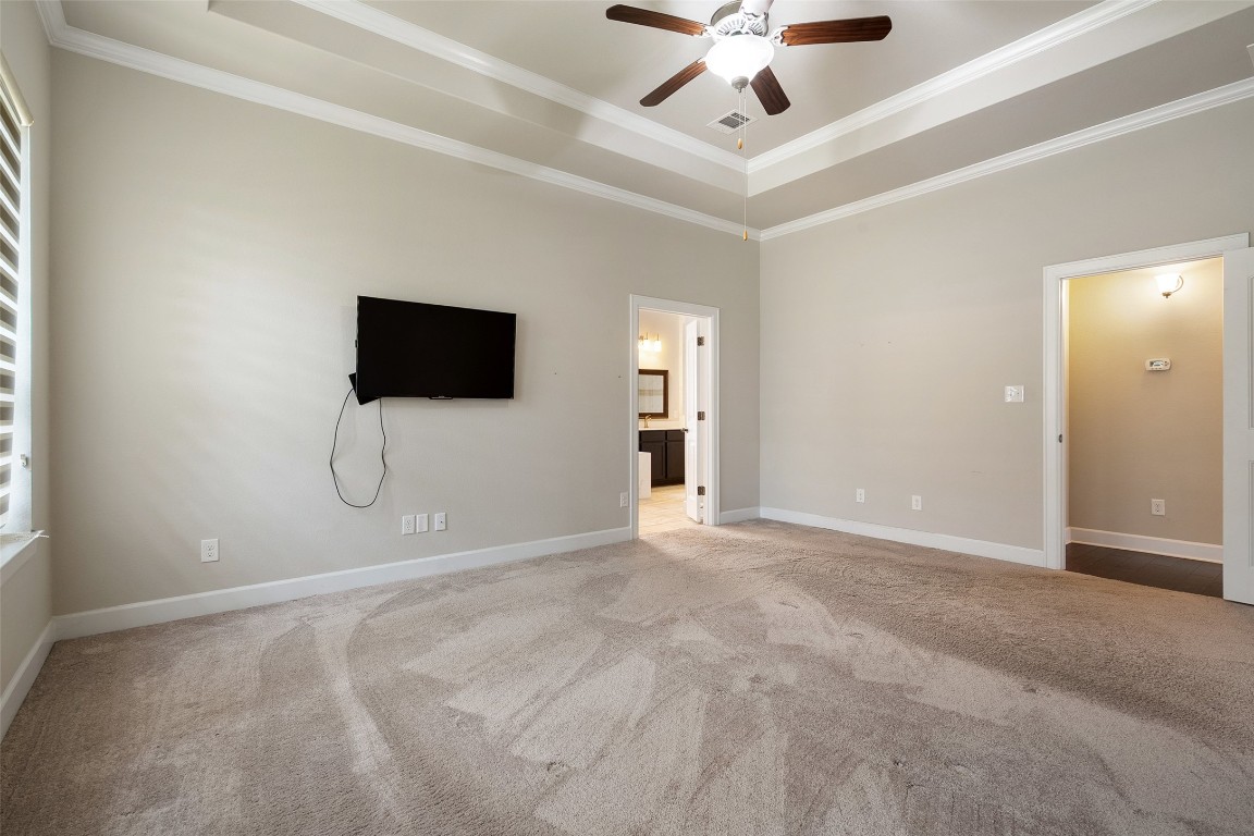 103 Lockhart Loop Georgetown, TX 78628 - Photo 29 of 40 Unfurnished bedroom with crown molding, a raised ceiling, carpet, and visible vents