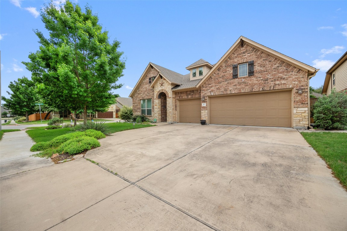 103 Lockhart Loop Georgetown, TX 78628 - Photo 4 of 40 a front view of a house with a garden and trees