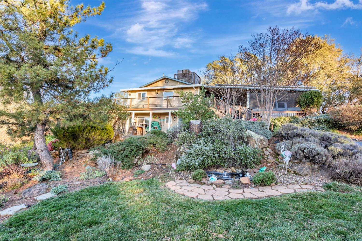 a view of a house with a yard and potted plants