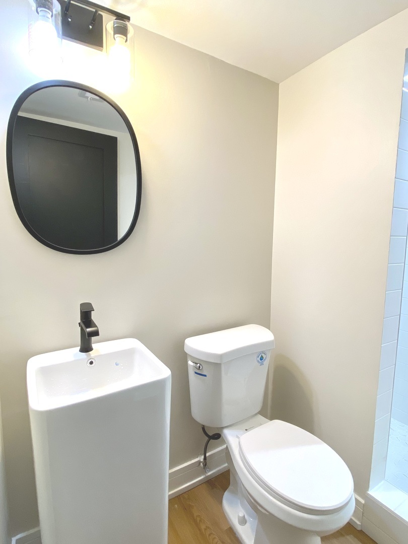 Undisclosed Address Chicago, IL 60619 - Photo 36 of 39 a white toilet sitting next to a bathroom sink