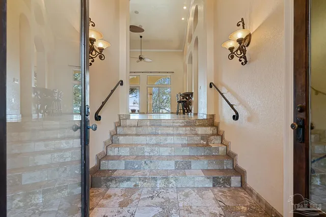 a view of hall with stainless steel appliances granite countertop and a view of living room