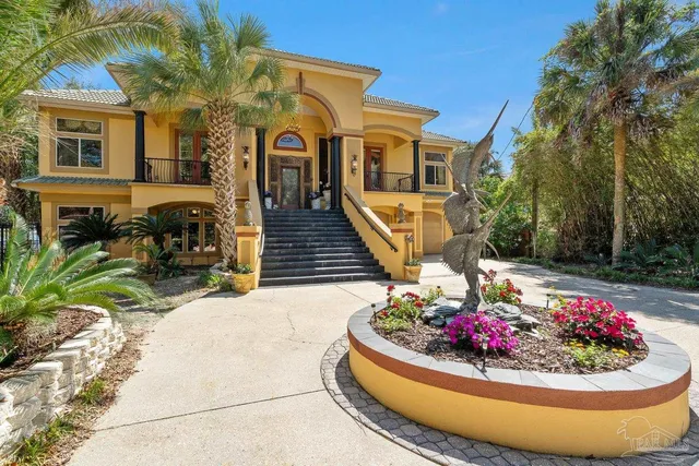 a view of a white house with a road and a tree