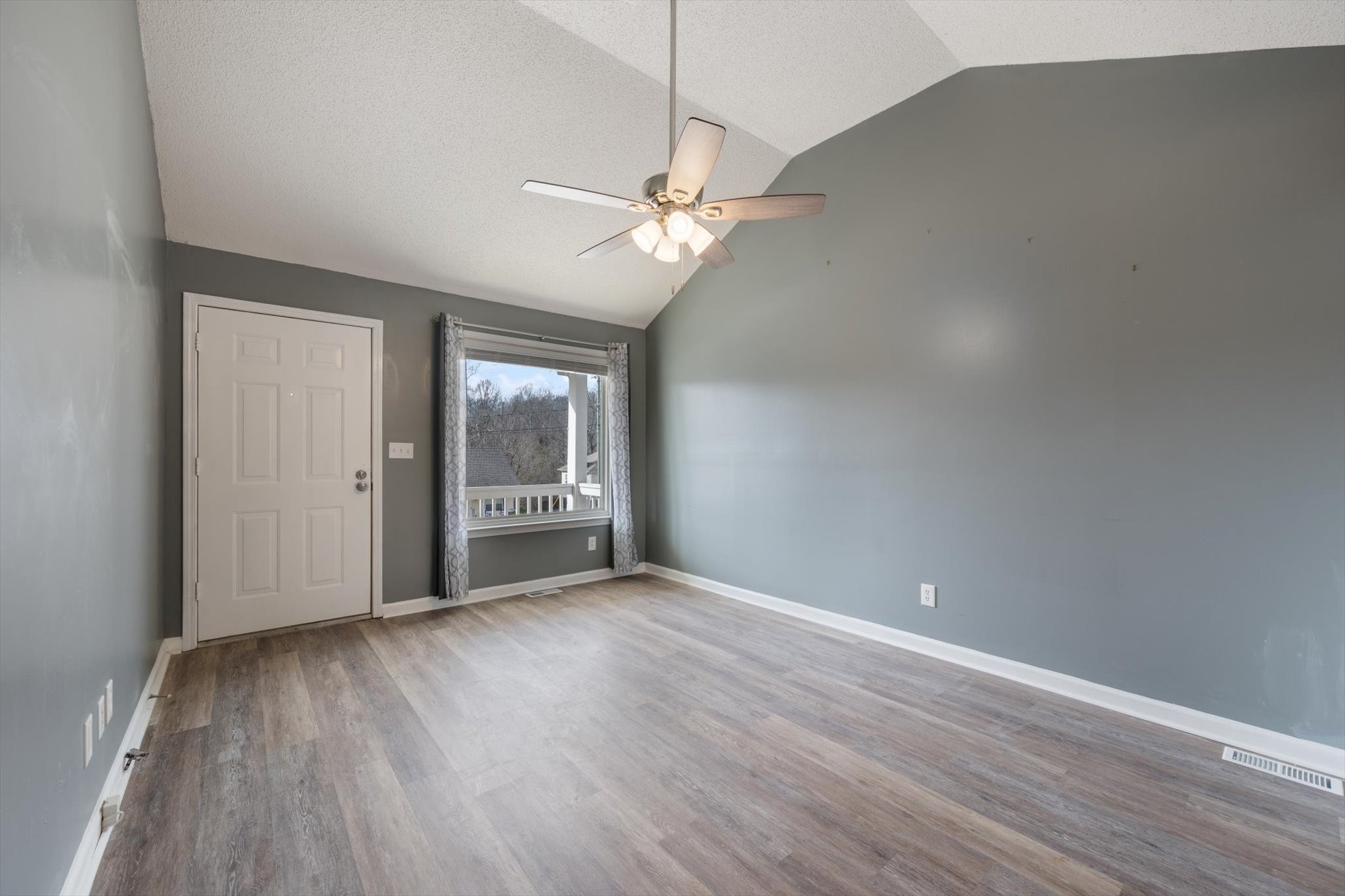1007 Granny White Road Clarksville, TN 37040 - Photo 13 of 27 an empty room with wooden floor a ceiling fan and windows