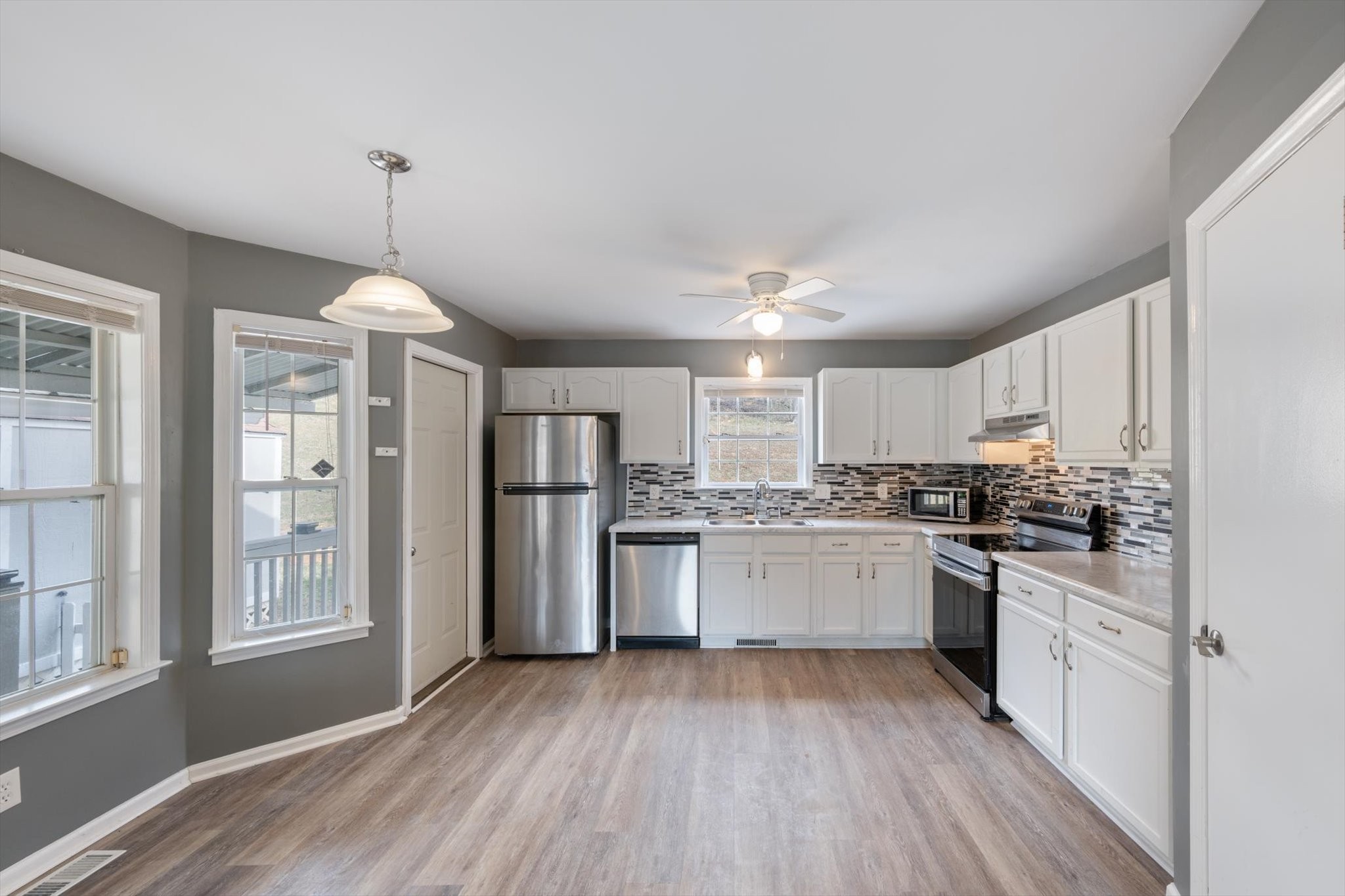 1007 Granny White Road Clarksville, TN 37040 - Photo 16 of 27 a kitchen with center island wooden floor stainless steel appliances and window