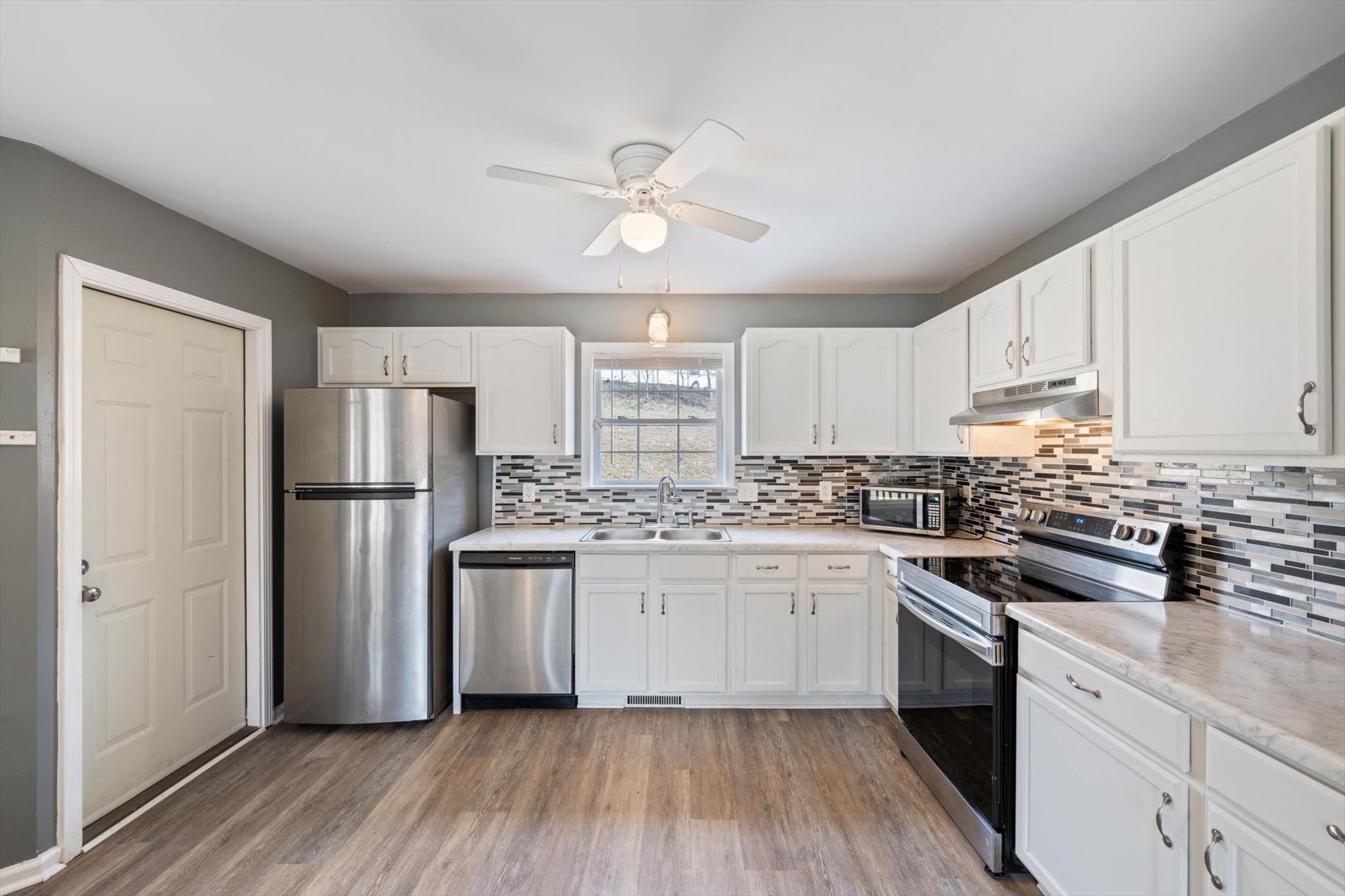 1007 Granny White Road Clarksville, TN 37040 - Photo 18 of 27 a kitchen with stainless steel appliances a sink cabinets and wooden floor