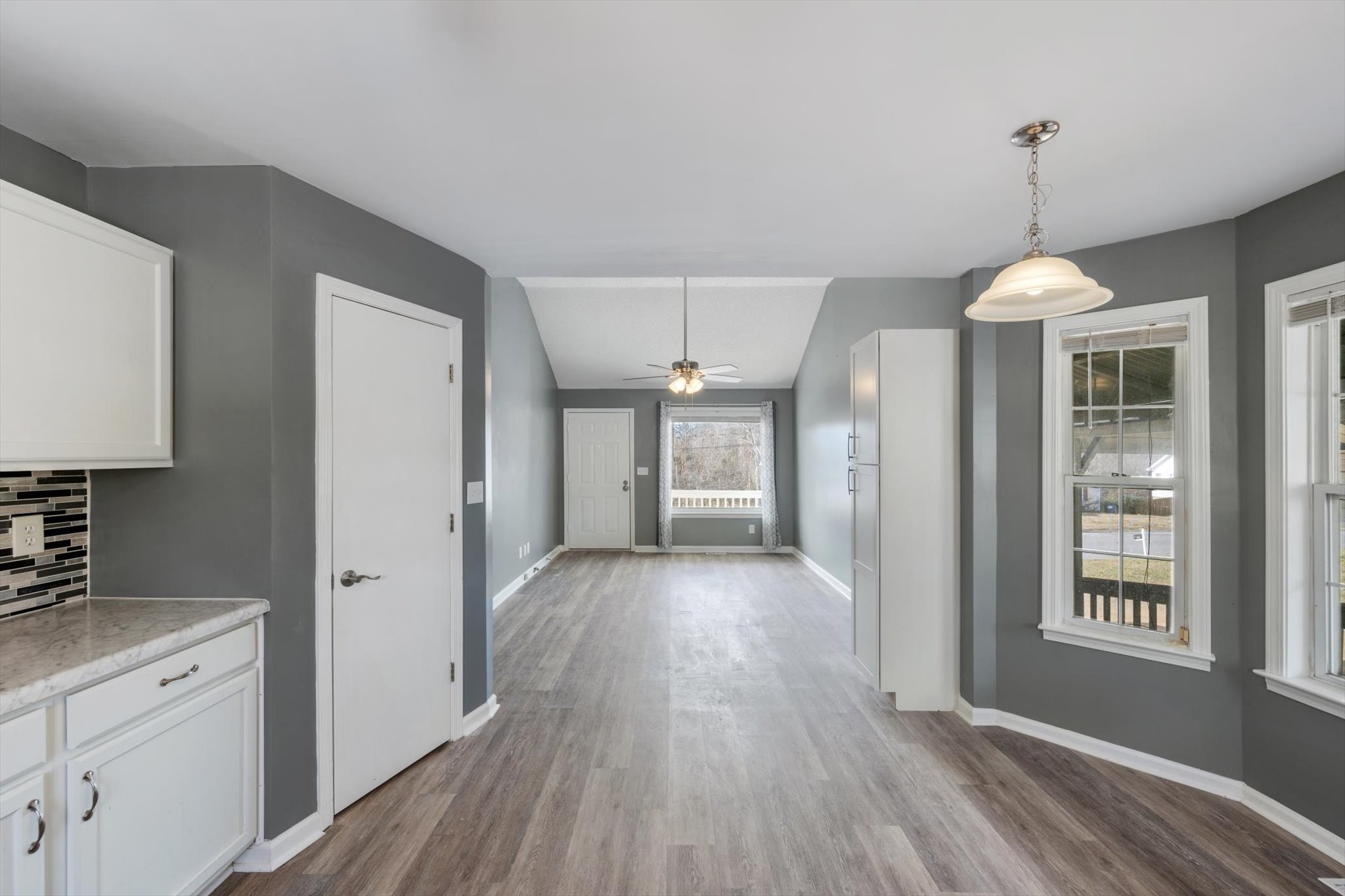1007 Granny White Road Clarksville, TN 37040 - Photo 20 of 27 a view of a kitchen and an empty room with wooden floor and windows