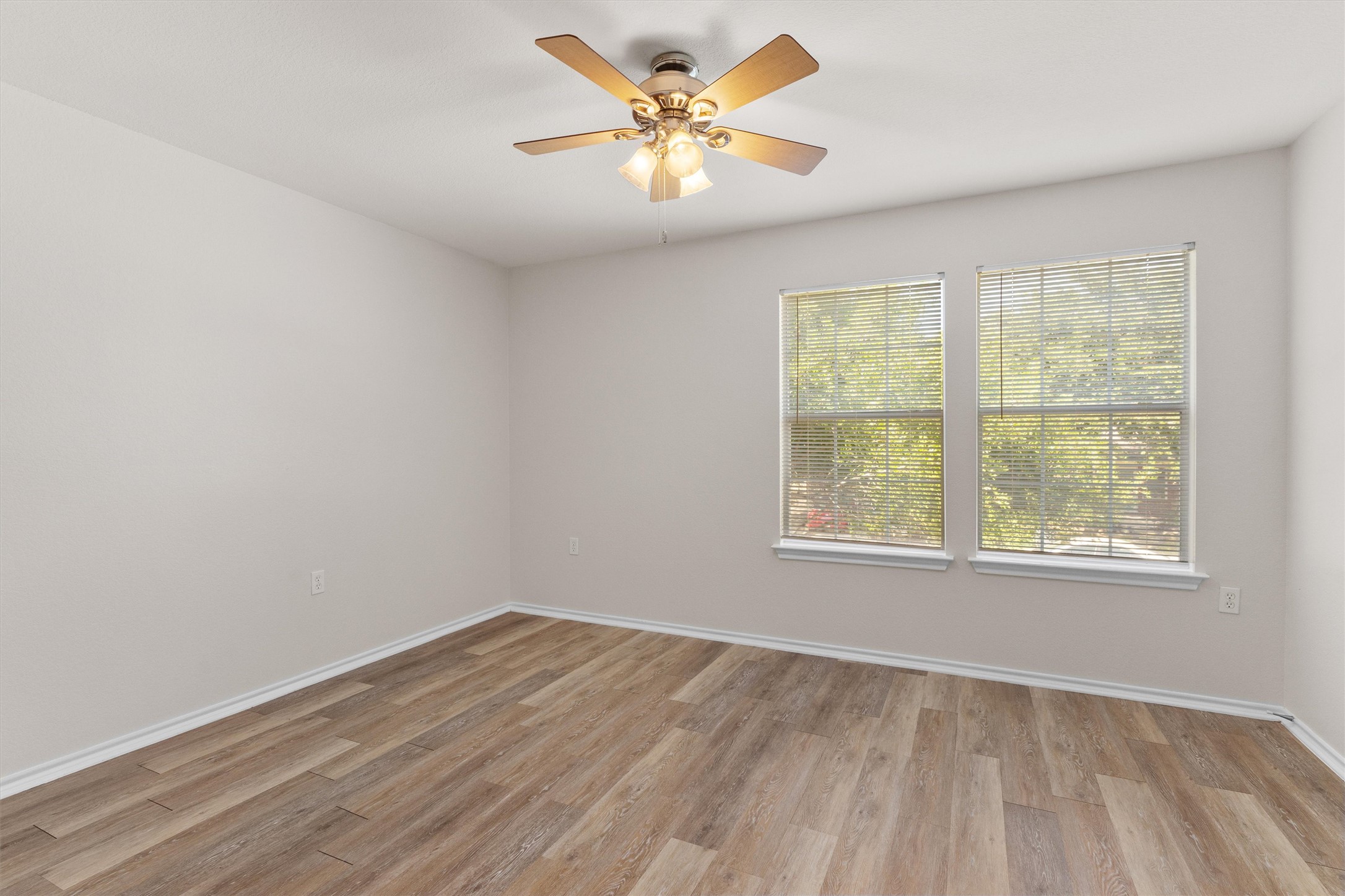5825 Silver Screen Drive Austin, TX 78747 - Photo 21 of 40 Well-lit room featuring durable wood-look flooring and a ceiling fan, offering comfortable living space.