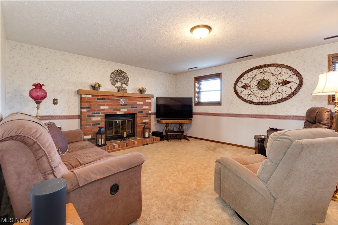 5419 Camp Road Ravenna, OH 44266 - Photo 21 of 32 Carpeted living room featuring a textured ceiling and a fireplace