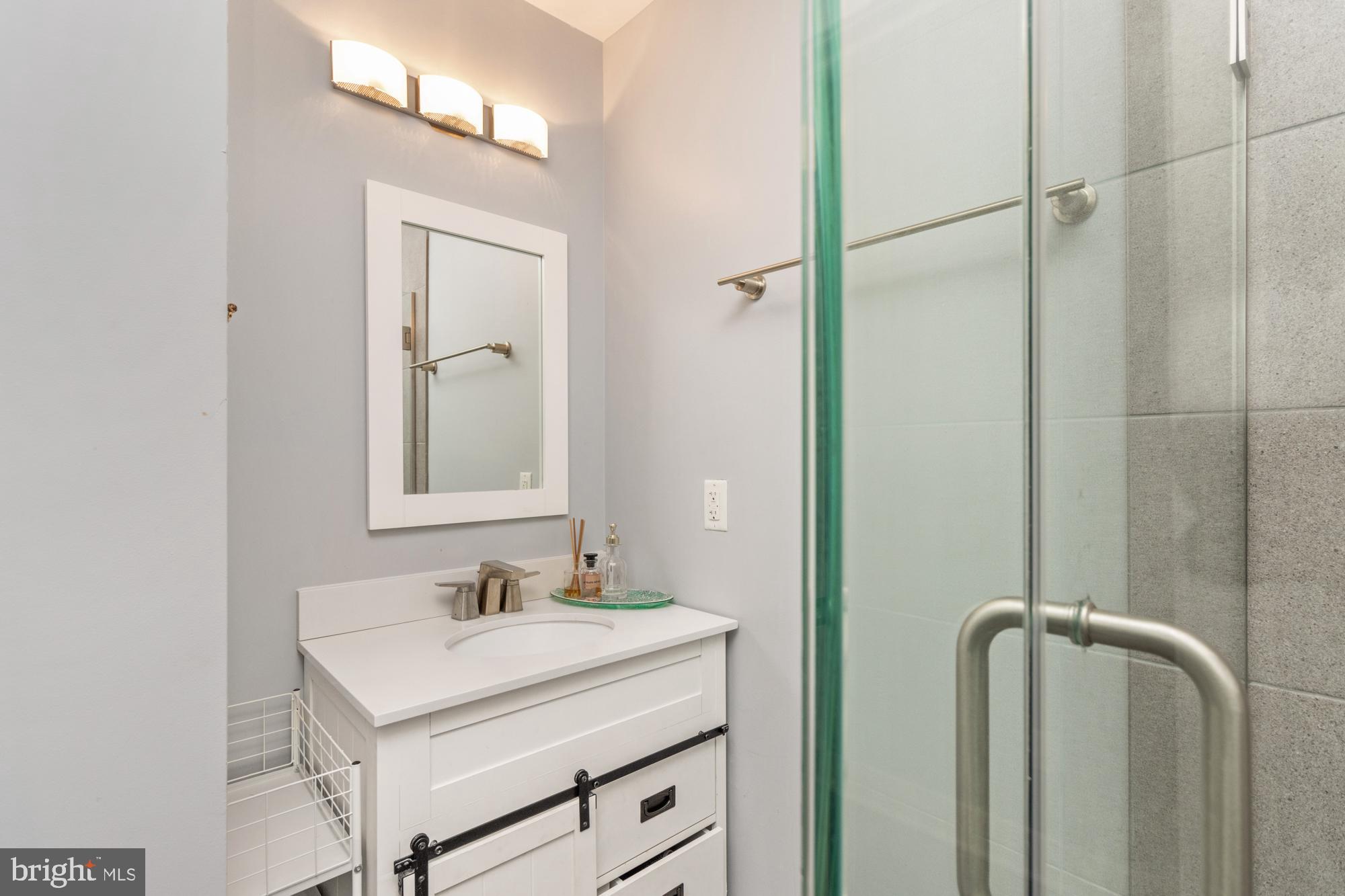 217 East Cross Street Baltimore, MD 21230 - Photo 28 of 50 a bathroom with a granite countertop sink mirror and vanity