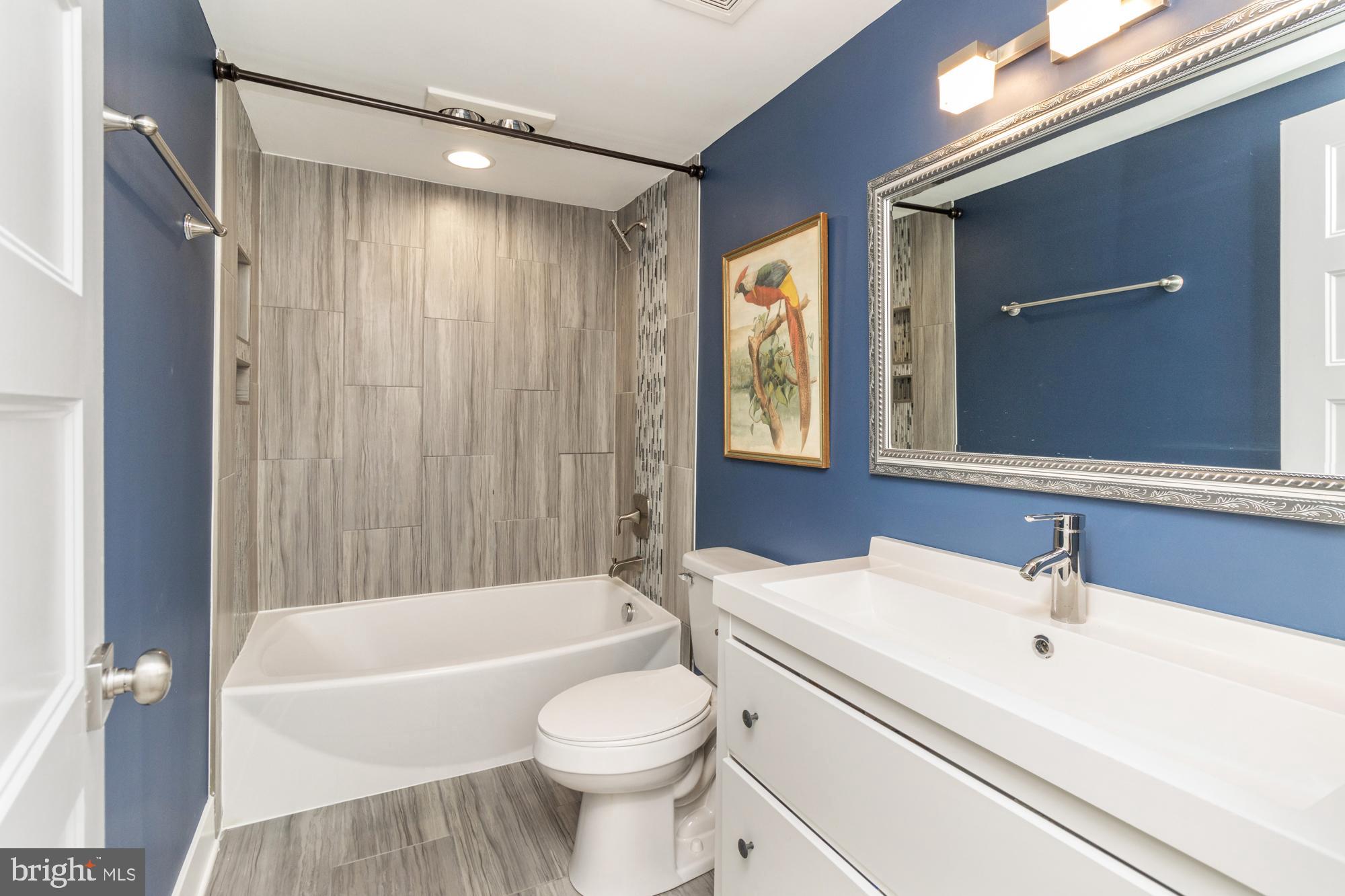217 East Cross Street Baltimore, MD 21230 - Photo 36 of 50 a bathroom with a sink a toilet a mirror and bathtub