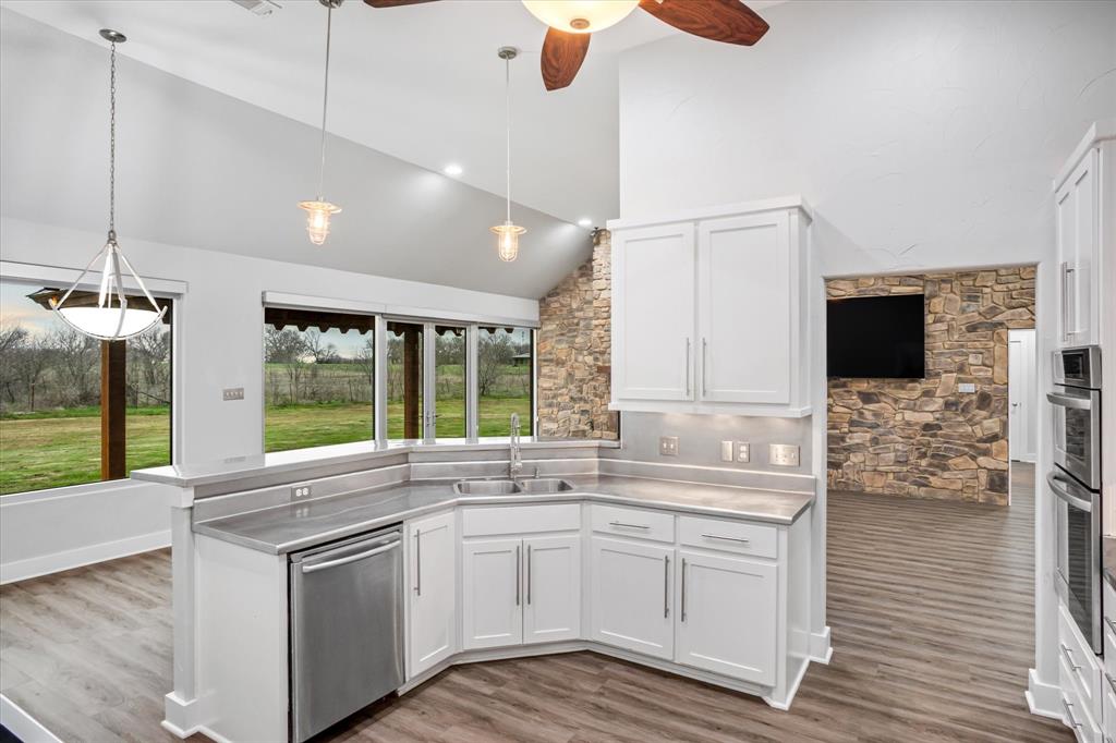 280 P East P Dawson Road, Unit E Maypearl, TX 76064 - Photo 7 of 11 Kitchen with stainless steel counters, a peninsula, hanging light fixtures, white cabinets, and high vaulted ceiling