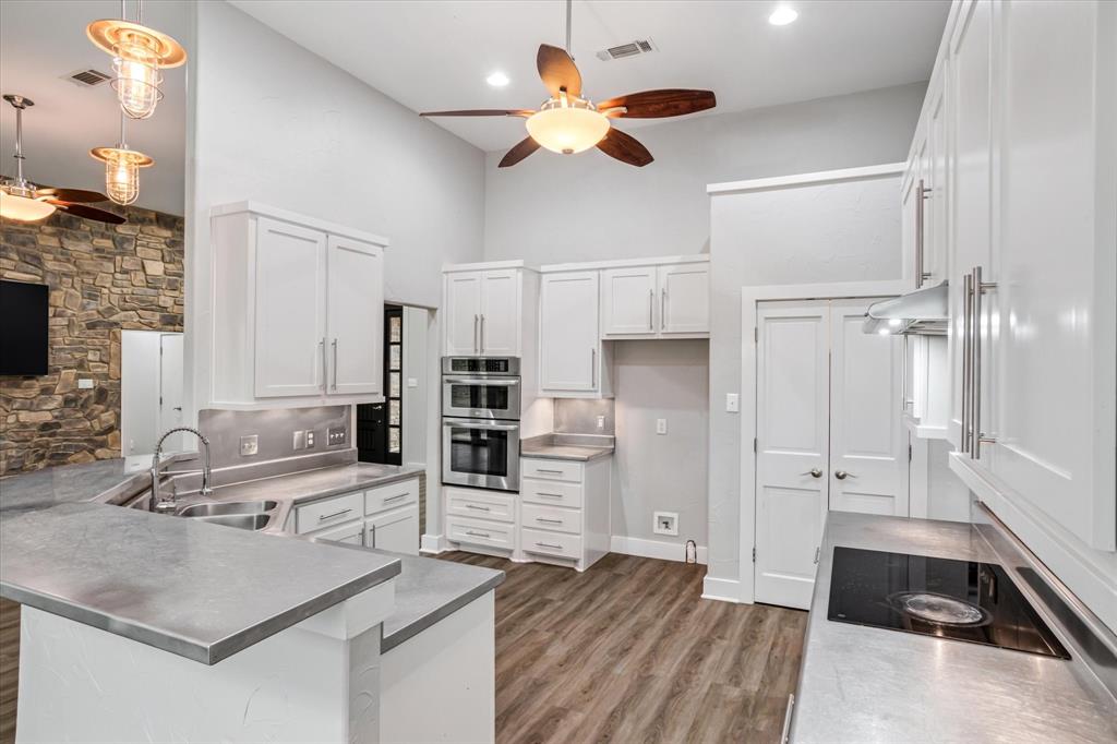 280 P East P Dawson Road, Unit E Maypearl, TX 76064 - Photo 8 of 11 Kitchen with stainless steel counters, a peninsula, white cabinetry, stainless steel double oven, and a towering ceiling