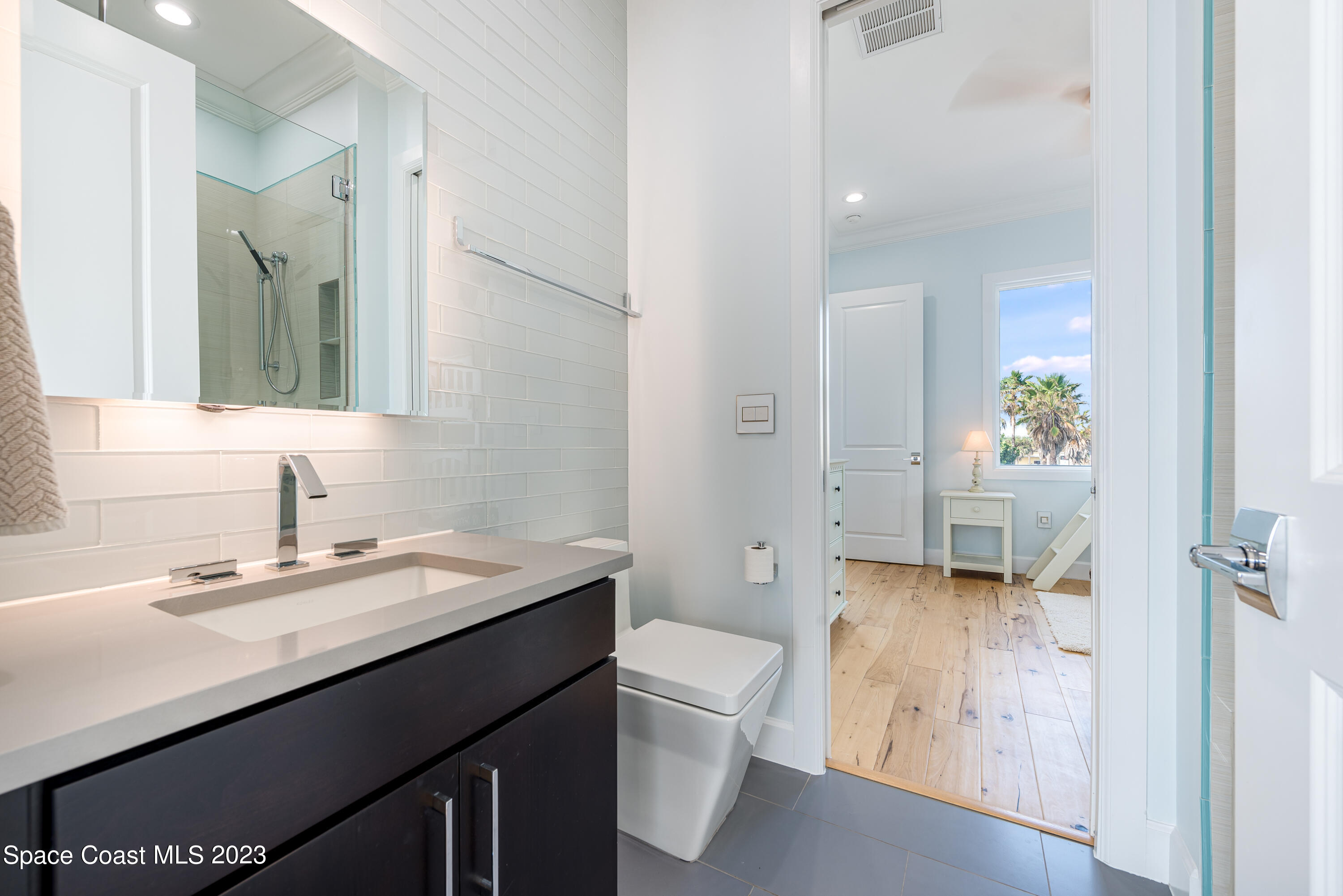 795 Shell Street Satellite Beach, FL 32937 - Photo 19 of 42 a en suite bathroom with a granite countertop sink a toilet and a mirror