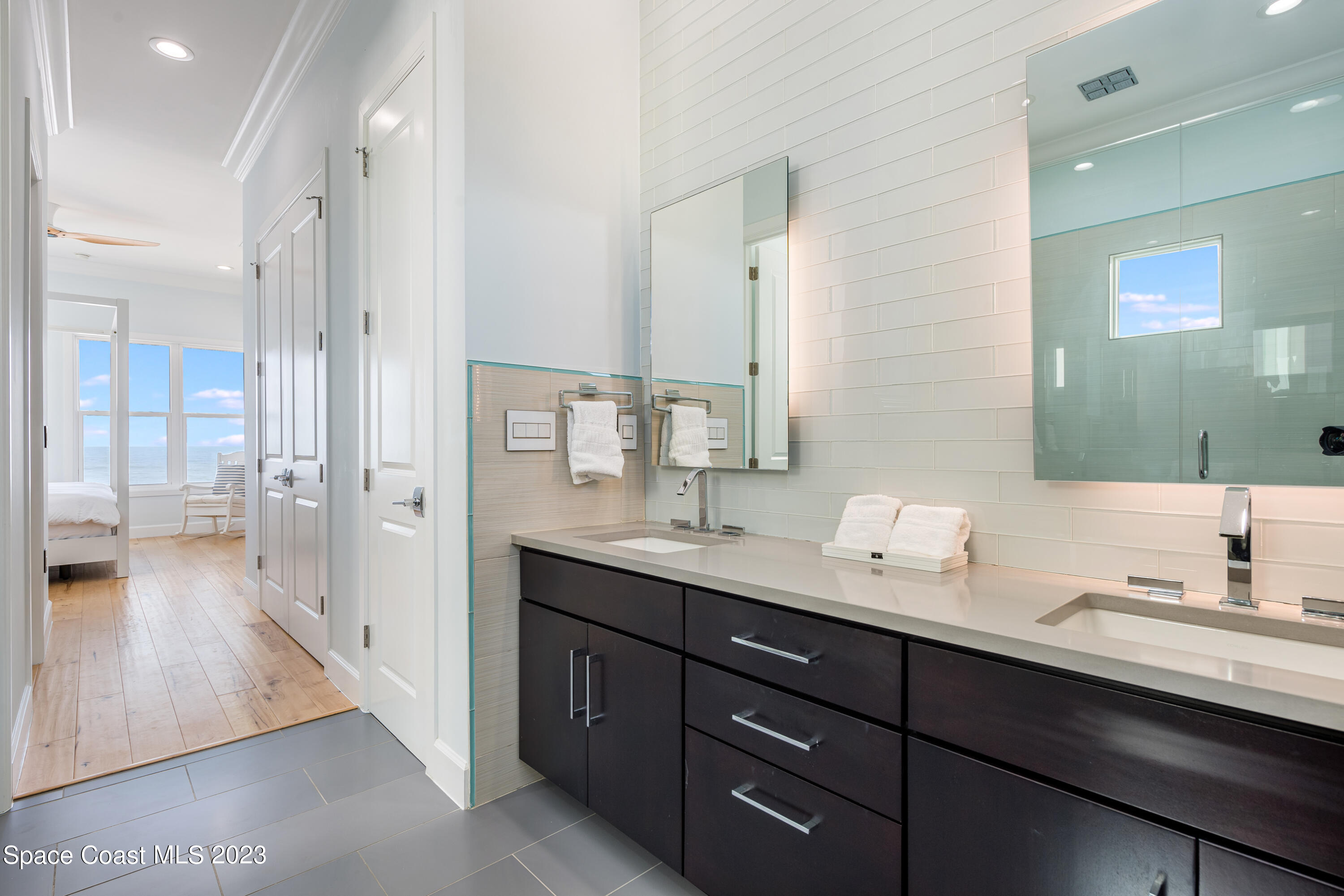 795 Shell Street Satellite Beach, FL 32937 - Photo 24 of 42 a en suite bathroom with a granite countertop sink mirror and double