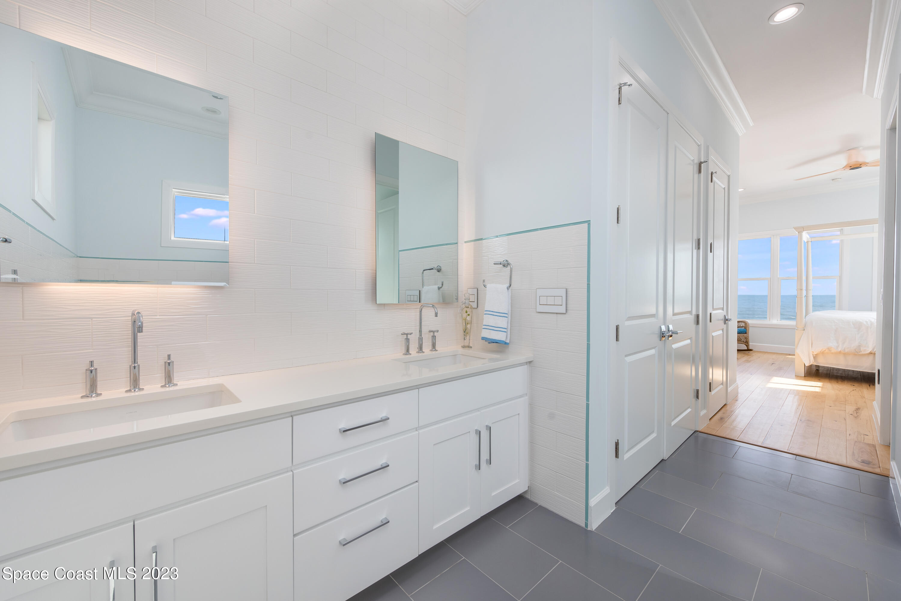 795 Shell Street Satellite Beach, FL 32937 - Photo 28 of 42 a spacious bathroom with a double vanity sink a mirror and a shower