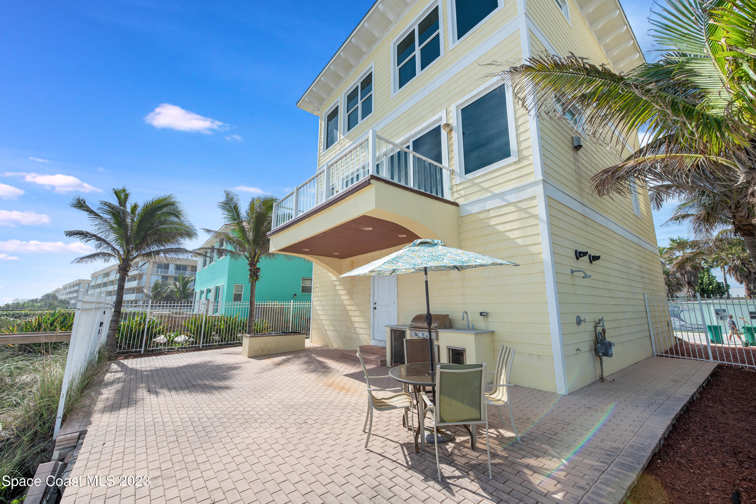 795 Shell Street Satellite Beach, FL 32937 - Photo 34 of 42 a patio with a table and chairs under an umbrella