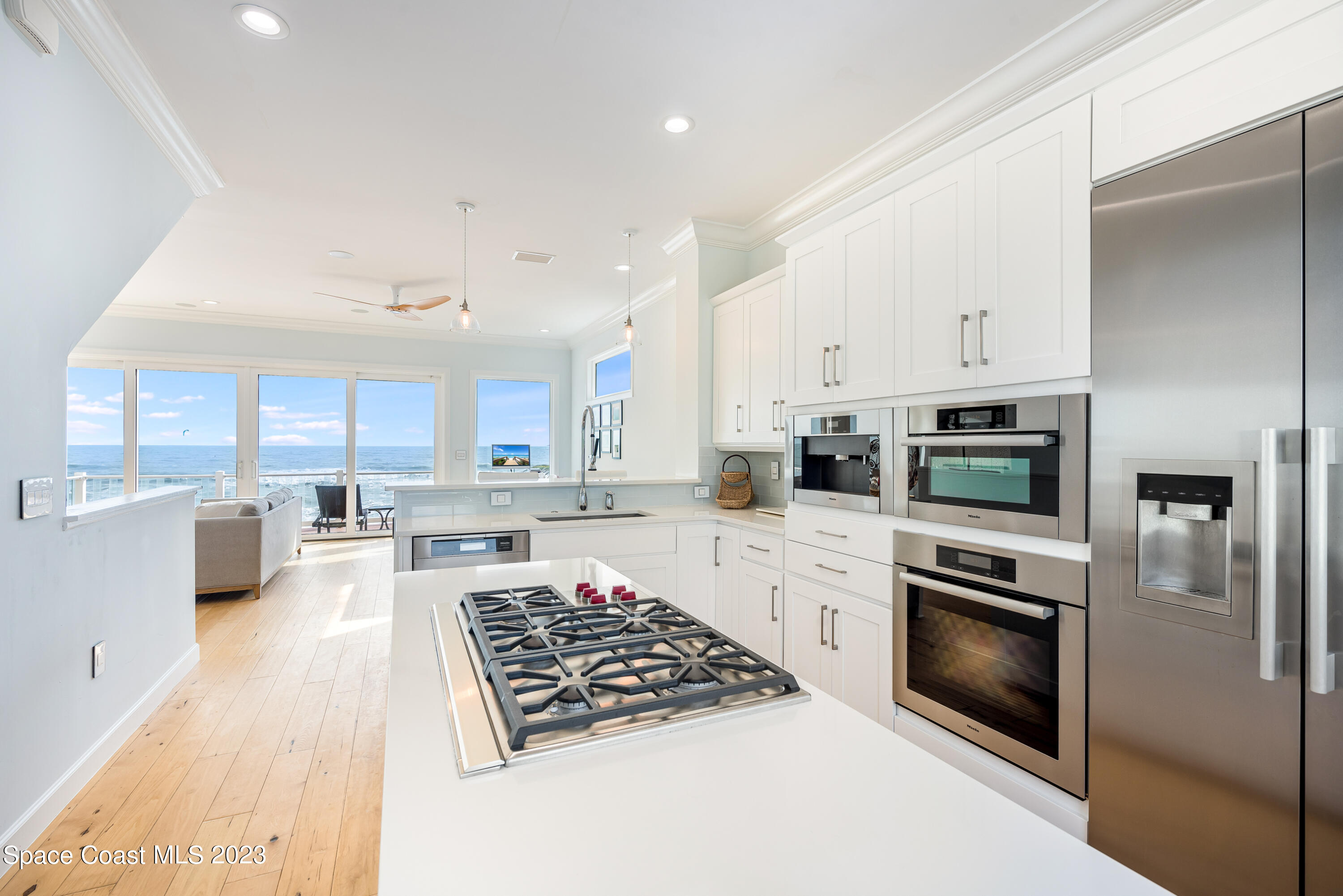 795 Shell Street Satellite Beach, FL 32937 - Photo 5 of 42 a kitchen with stainless steel appliances a stove a sink a microwave a refrigerator and white cabinets