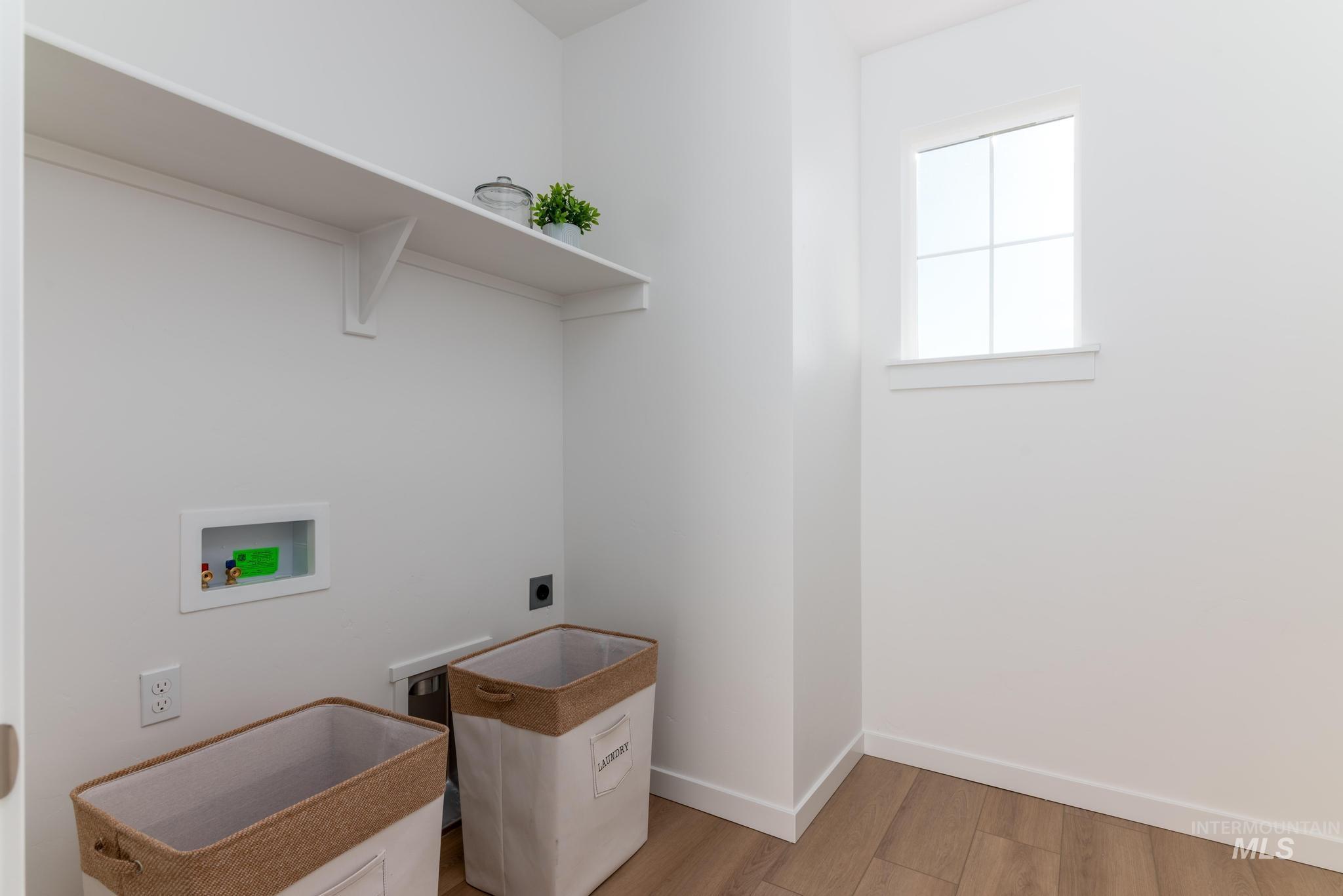 8409 South Wavecrest Avenue Kuna, ID 83634 - Photo 11 of 12 Laundry room with hookup for a washing machine, light wood-style floors, and electric dryer hookup