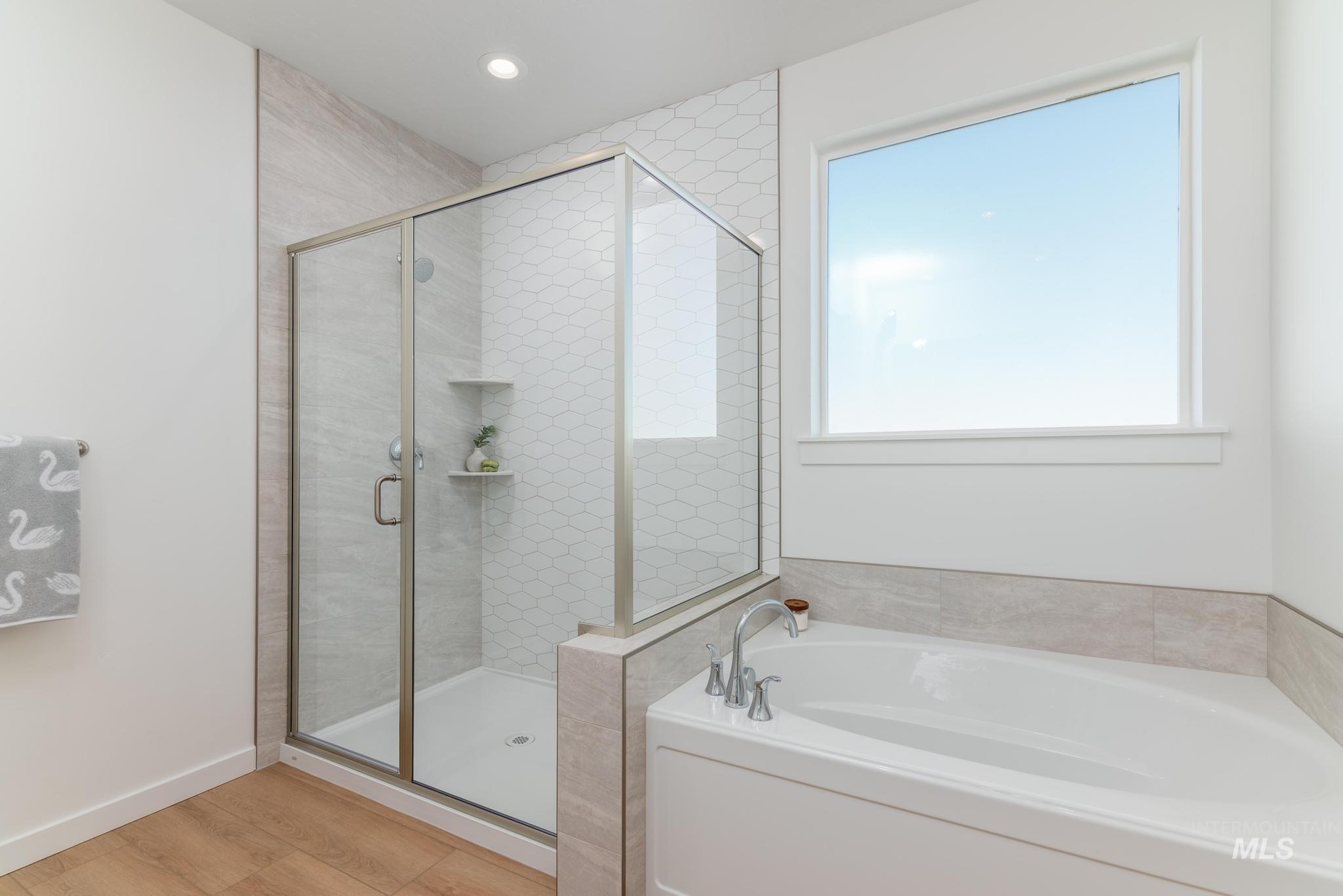 8409 South Wavecrest Avenue Kuna, ID 83634 - Photo 10 of 12 Bathroom with a bath, a stall shower, healthy amount of natural light, light wood-type flooring, and recessed lighting