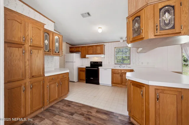 a kitchen with stainless steel appliances granite countertop a refrigerator and a stove top oven